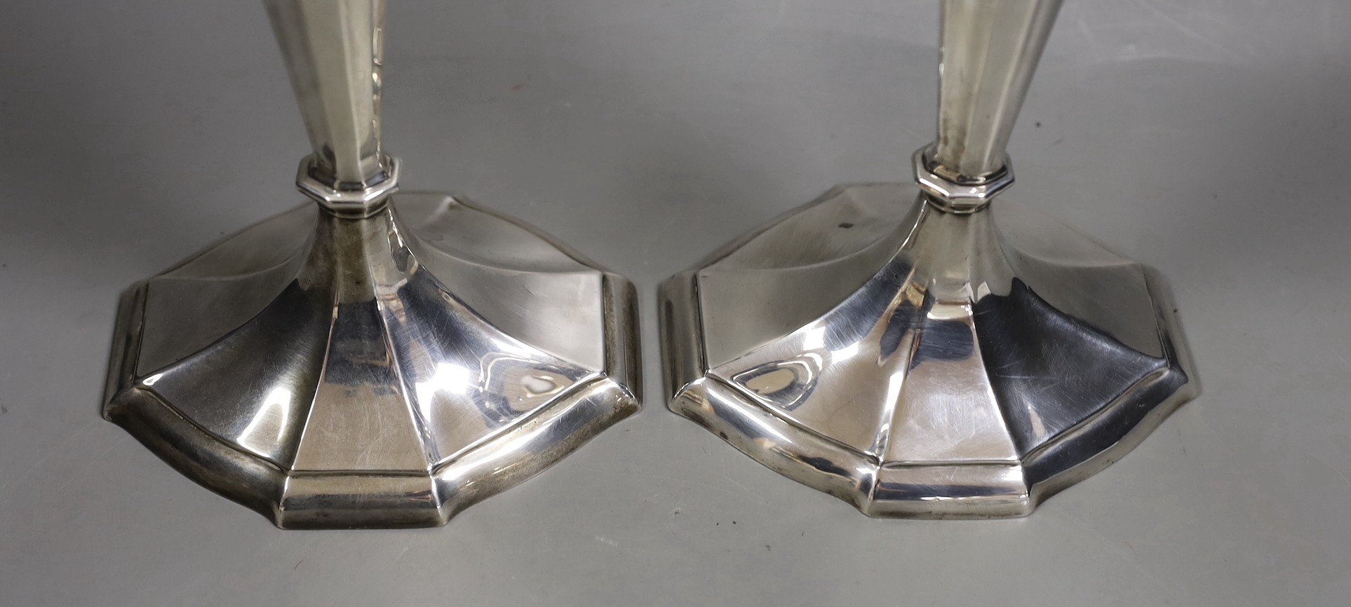 A pair of North American sterling candlesticks, with panelled stems and shaped oval bases, 34.1cm, weighted.